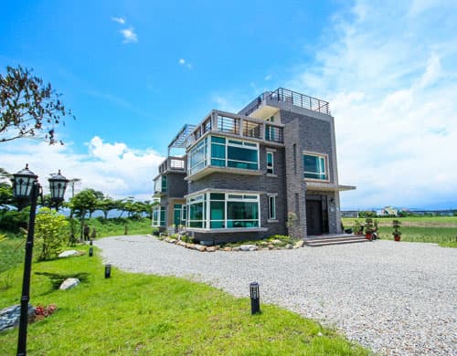 Water Edge Garden Homestayの建物外観と芝生