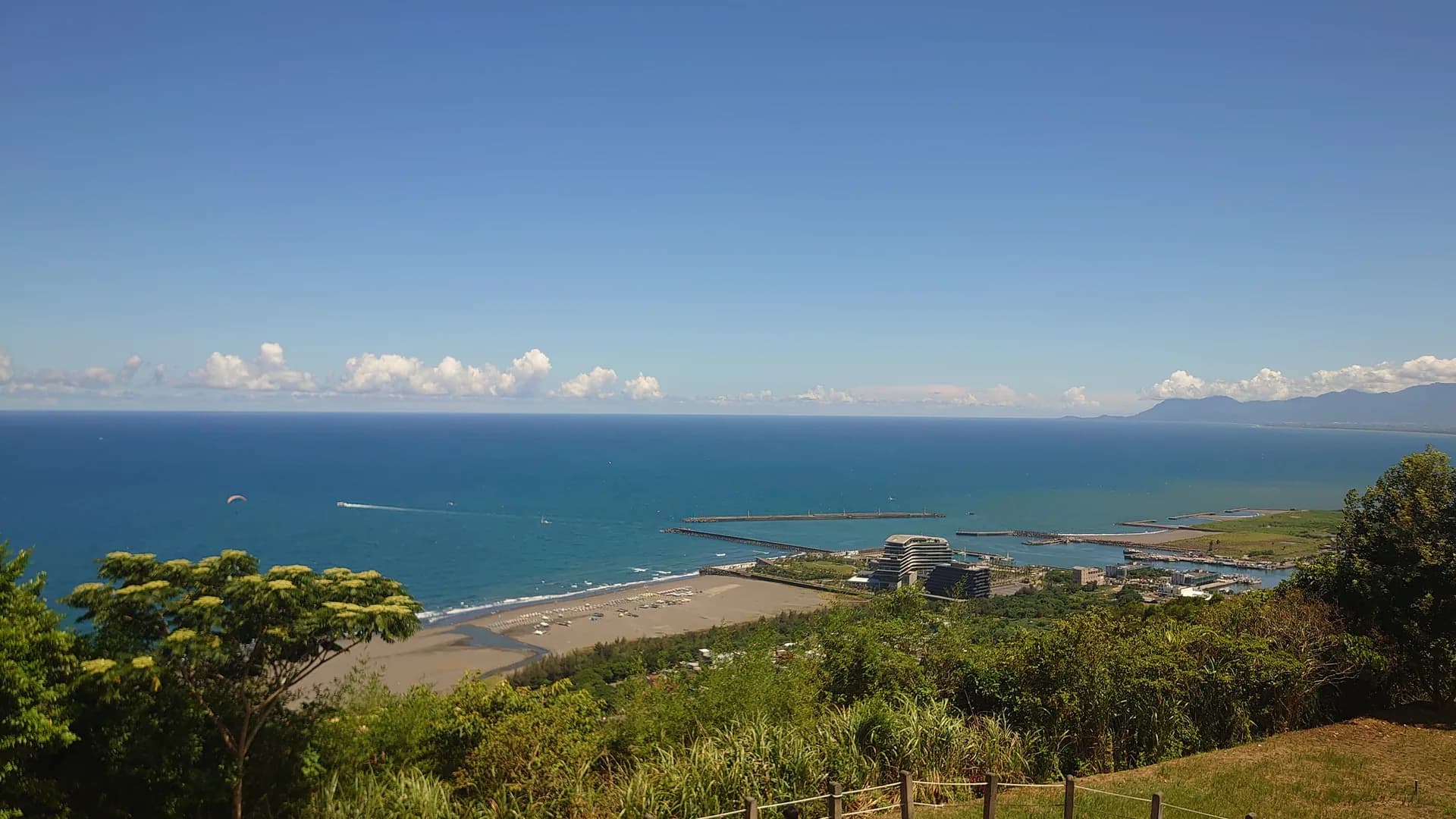 Blick von oben auf den dunklen Sandstrand von Wai'ao, das Meer und die äußere Küste von Wushi Harbor